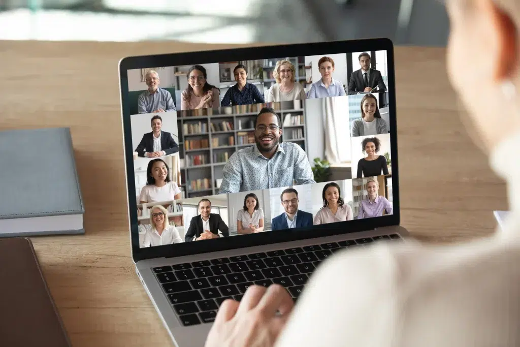 Hintergrundaufnahme einer Frau, die an ihrem Laptop eine Online-Konferenz mit ihren Kollegen abhält