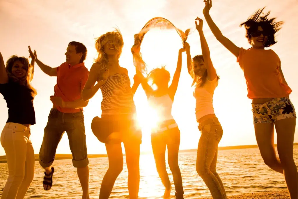 eine Gruppe junger Menschen, die am Strand tanzen
